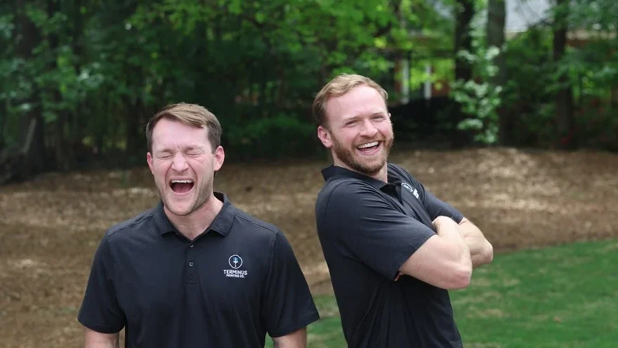 Colin and Conner, founders of Terminus Painting Co., laughing together outdoors